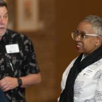 three people talk in the hallway at celebration event